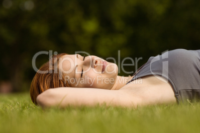 Pretty redhead lying with her eyes closed