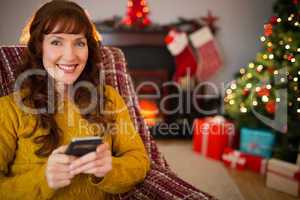 Happy redhead using mobile at christmas