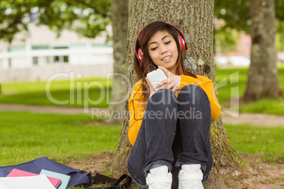 Relaxed woman enjoying music in park