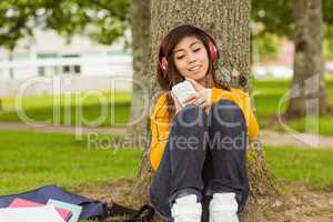 Relaxed woman enjoying music in park