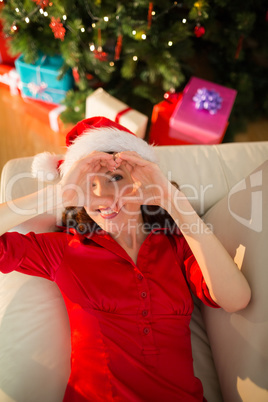 Smiling redhead making heart with her hands