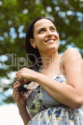 Portrait of a smiling brunette holding her braid