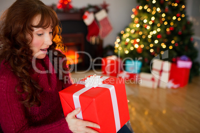 Surprised redhead holding present at christmas