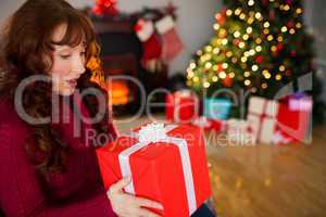 Surprised redhead holding present at christmas