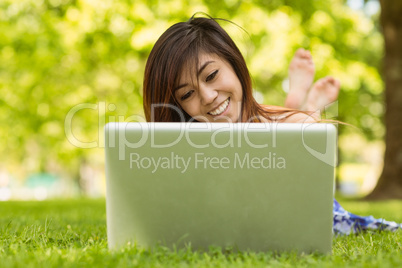 Relaxed woman using laptop in park