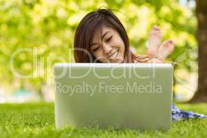 Relaxed woman using laptop in park