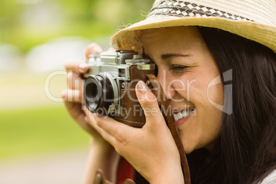 Happy brunette taking photo with retro camera