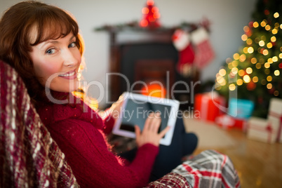 Beauty redhead using tablet at christmas