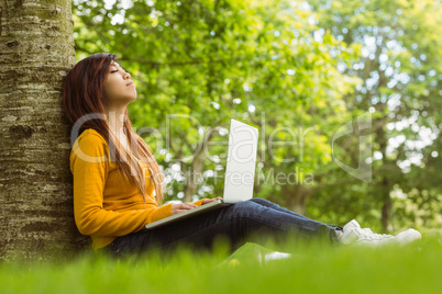 Relaxed woman using laptop in park