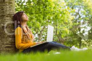Relaxed woman using laptop in park