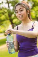 Healthy woman holding water bottle in park