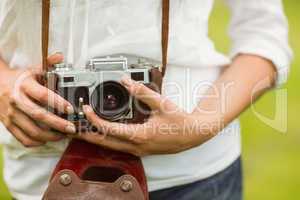 Mid section of woman holding vintage camera