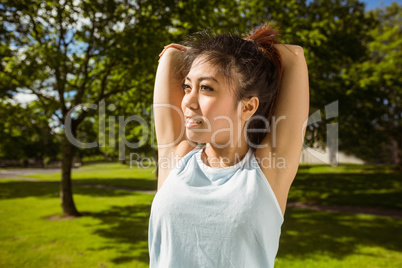 Healthy woman stretching hands in park
