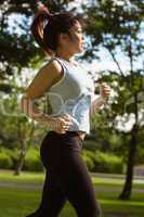 Side view of healthy woman jogging in park