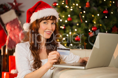 Smiling redhead shopping online with laptop