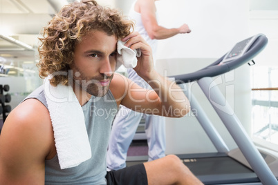 Handsome tired young man in gym