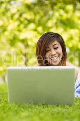 Relaxed woman using laptop in park