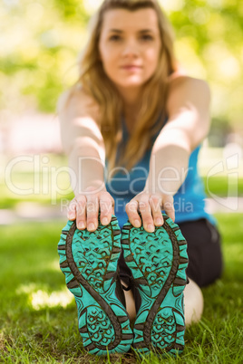 Fit blonde stretching on the grass