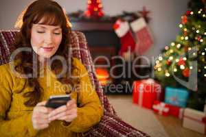 Content redhead using mobile at christmas