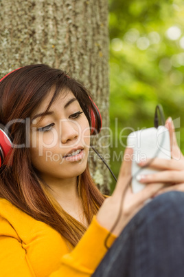 Beautiful woman enjoying music in park