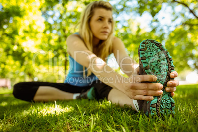 Fit blonde stretching on the grass