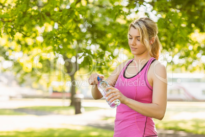 Fit blonde opening her water bottle