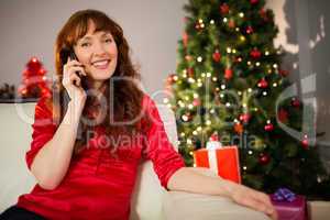 Pretty redhead sitting on the couch phoning