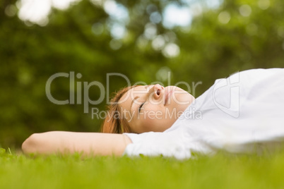 Pretty redhead lying with her eyes closed