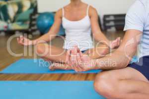 Couple sitting in lotus posture at fitness studio