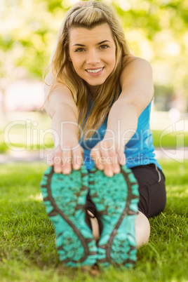 Fit blonde stretching on the grass