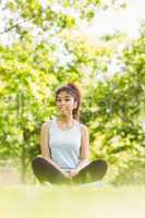 Healthy woman sitting on grass in park