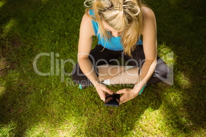 Fit blonde texting on her smartphone