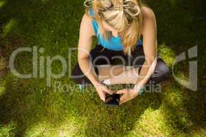 Fit blonde texting on her smartphone