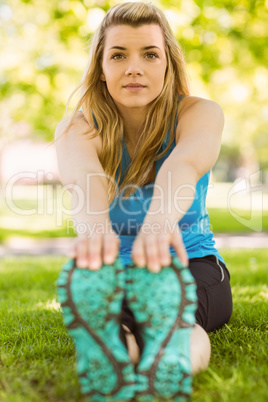 Fit blonde stretching on the grass