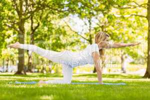 Fit blonde doing yoga in the park