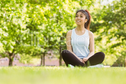 Healthy woman sitting on grass in park