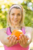 Fit blonde holding an orange