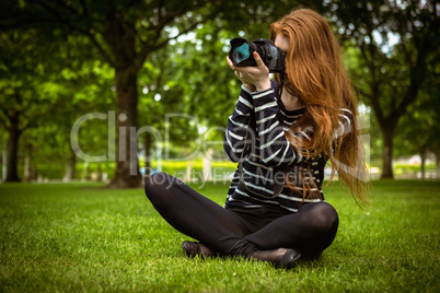 Female photographer sitting on grass