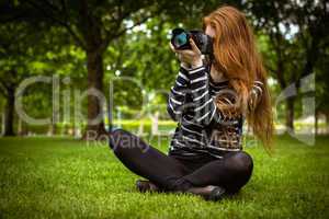 Female photographer sitting on grass