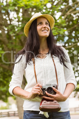 Smiling brunette holding old fashioned camera