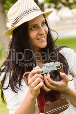 Happy brunette in straw hat holding retro camera