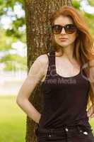 Beautiful woman against tree in park