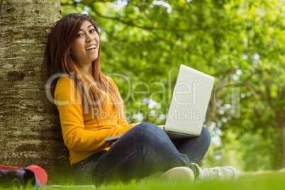 Relaxed woman using laptop in park