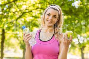 Fit blonde holding water and apple