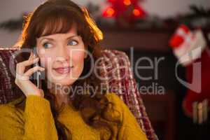 Cheerful redhead on the phone at christmas