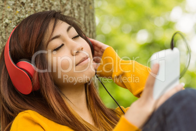 Relaxed woman enjoying music in park