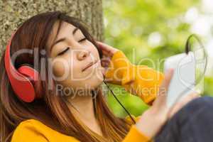 Relaxed woman enjoying music in park