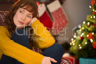 Beauty red hair thinking on the armchair at christmas