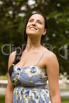Smiling brunette in dress enjoying the sunshine