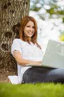 Pretty redhead sitting with her laptop
